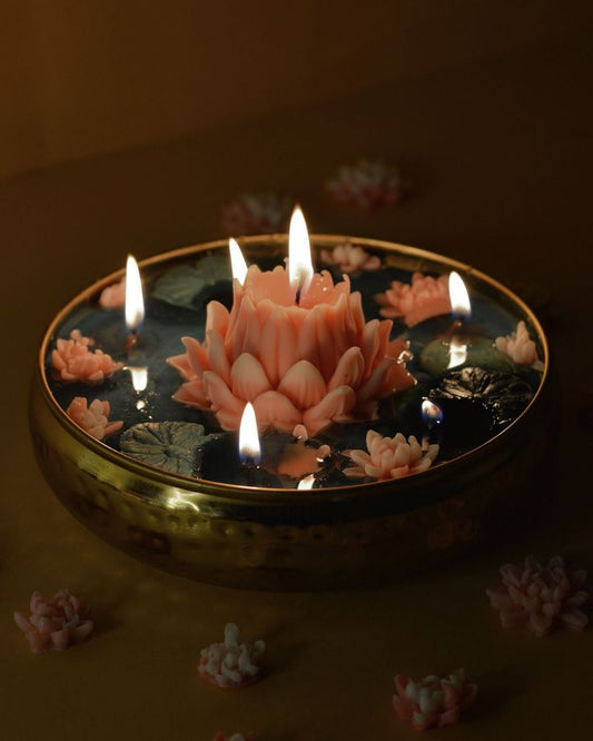 Decorative candle shaped like a lotus flower with flames on a dark background