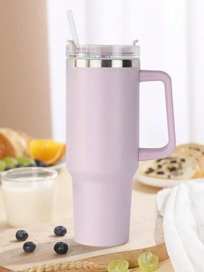 Purple insulated mug with handle on a table with fruits and pastries