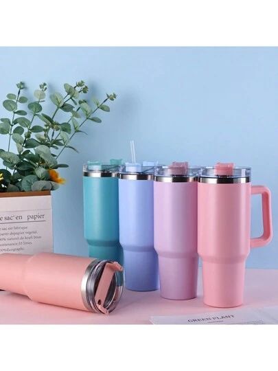 Set of colorful tumblers with handles on a light blue background
