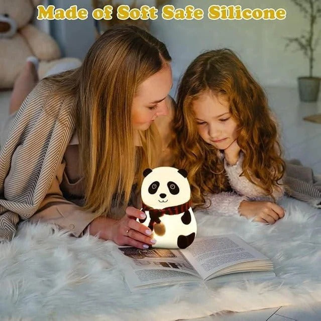 Woman and child reading a book together with a panda-shaped night light on a bed.